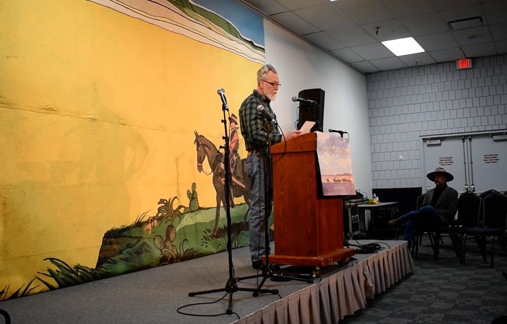 Performing at a podium on stage at the National Cowboy Gathering in Elko, Nevada