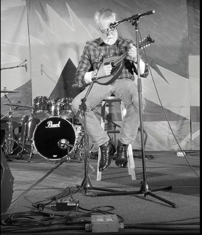 Black and white photo of a musician playing guitar on stage