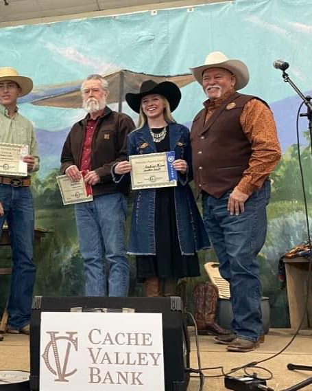Award winners holding certificates on stage at the Cache Valley Rendezvous